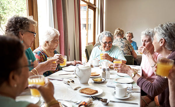 Shot of a group of seniors enjoying breakfast together in their retirement home